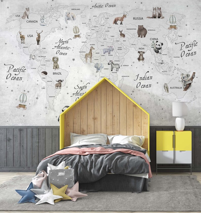 Puede incluir: Un mural de pared que muestra un mapa del mundo con ilustraciones de varios animales y globos aerost&aacute;ticos. El mapa incluye etiquetas de continentes y oc&eacute;anos. Una estructura de cama en forma de casa con cabecero de madera se sit&uacute;a delante.
