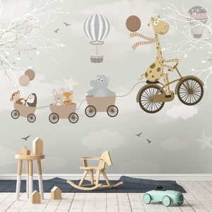 May include: A wall mural featuring a cartoon giraffe riding a bicycle, pulling a train of three small wagons filled with a monkey, penguin, rabbit, fox, and hippo. The scene includes hot air balloons, white tree branches, and stars on a gray background.