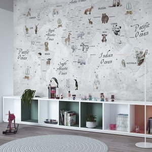 Puede incluir: Un gran mural de pared que muestra un mapa del mundo con contornos grises, oc&eacute;anos etiquetados y varios animales ilustrados colocados en los continentes. El mapa incluye texto para oc&eacute;anos y pa&iacute;ses sobre un fondo gris texturizado.