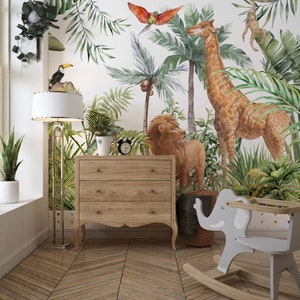 May include: A wall mural featuring a watercolor jungle scene with a giraffe, lion, monkey, toucan, and parrot amidst palm trees and foliage. A light wood three-drawer dresser, a floor lamp, and a gray elephant-shaped rocking chair are present.