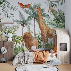 May include: A wall mural featuring a jungle scene with a giraffe, a lion, a monkey, and a parrot amidst palm leaves. A wooden house-shaped bed frame sits in front of the mural, with a white and orange patterned bedspread and a round world map rug.