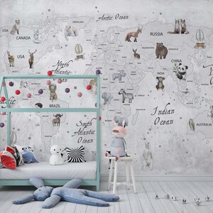 Puede incluir: Un mural de pared que muestra un mapa del mundo con ilustraciones de animales y etiquetas geogr&aacute;ficas, incluyendo Arctic Ocean, Pacific Ocean e Indian Ocean. El mapa se muestra detr&aacute;s de una estructura de cama azul claro y un taburete blanco.