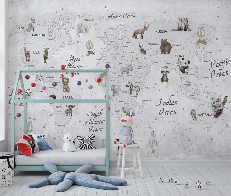 Puede incluir: Un mural de pared que muestra un mapa del mundo con ilustraciones de animales y etiquetas geogr&aacute;ficas, incluyendo Arctic Ocean, Pacific Ocean e Indian Ocean. El mapa se muestra detr&aacute;s de una estructura de cama azul claro y un taburete blanco.