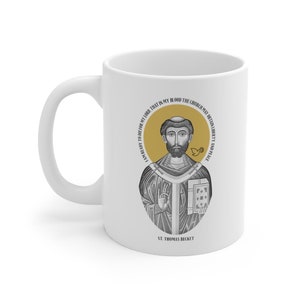 Puede incluir: Taza de cerámica blanca con una ilustración en blanco y negro de San Tomás Becket. La taza tiene un círculo dorado alrededor de la ilustración con el texto "Estoy dispuesto a morir por mi Señor, para que en mi sangre la Iglesia pueda obtener libertad y paz." El texto "San Tomás Becket" está impreso debajo de la ilustración.