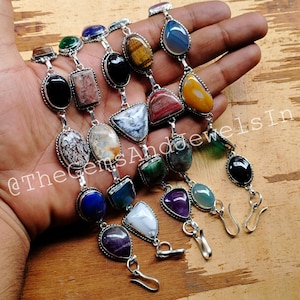Peut inclure: Un bracelet en argent avec une variété de perles de pierres précieuses, dont l'améthyste, l'agate, l'œil de tigre et le lapis-lazuli. Le bracelet est doté d'une fermeture à fermoir et est décoré d'accents argentés. @TheGemsAndJewelsIn