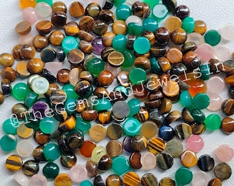Peut inclure: Une collection de pierres précieuses cabochon assorties de différentes couleurs, notamment le vert, le brun, le rose et le violet. Les pierres précieuses sont rondes et ont une finition lisse et polie. Elles sont idéales pour la fabrication de bijoux ou d'autres projets d'artisanat.