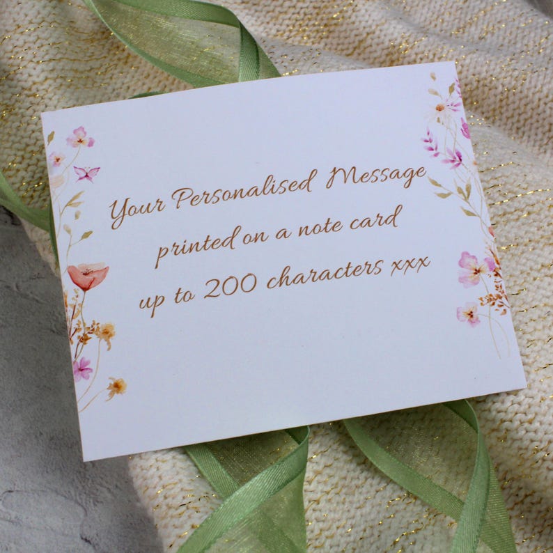 Peut inclure: Une carte blanche avec un motif floral et le texte "Your Personalised Message printed on a note card up to 200 characters xxx".