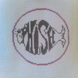 May include: A white canvas with a red and blue circle border. Inside the circle is a black and white cross-stitch design of the word "FISH" in a stylized font.