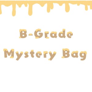 Puede incluir: Un gráfico de texto marrón sobre un fondo blanco con pintura amarilla goteando por encima del texto. El texto dice "B-Grade Mystery Bag".