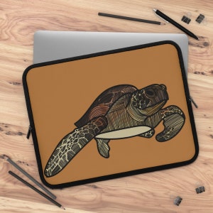May include: A brown laptop sleeve with a black zipper and a detailed line drawing of a sea turtle in shades of brown, black, and white.