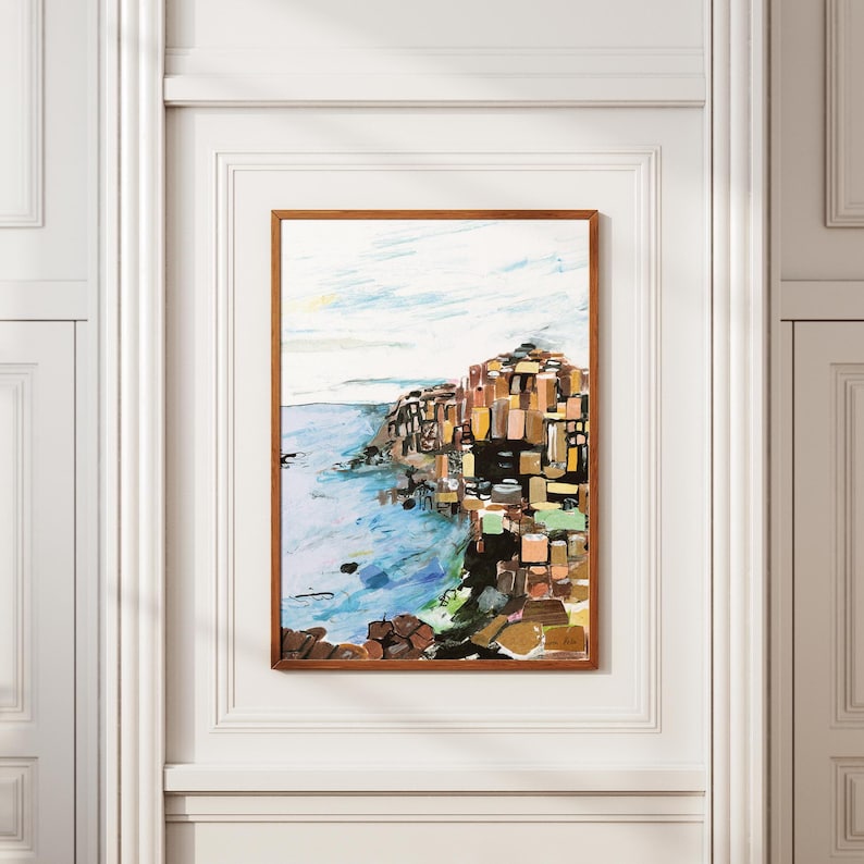May include: A painting of a rocky cliffside with a blue ocean in the foreground. The cliff is made up of many different colored blocks, creating a mosaic effect. The sky is a light blue with white clouds.