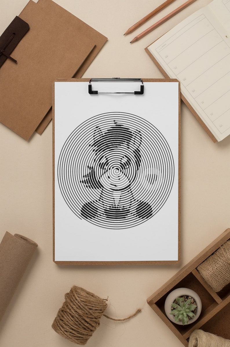 May include: A black and white spiral art print of a bear on a clipboard. The artwork is centered on a white sheet of paper, with a wooden clipboard frame. The image is surrounded by stationery and craft supplies.