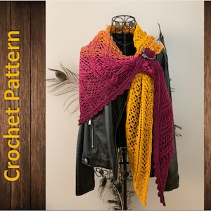 May include: A crochet shawl with a gradient of burgundy and yellow colours. The shawl is draped over a mannequin wearing a black leather jacket.