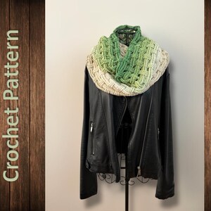 Könnte beinhalten: Ein handgefertigter Crochet-Loop-Schal in Grün- und Cremetönen, drapiert über einer schwarzen Lederjacke. Der Schal hat ein strukturiertes, gewebtes Muster. Das Bild ist vor einem neutralen Hintergrund mit dem Text "Crochet Pattern" links platziert.