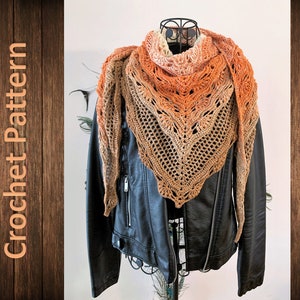 May include: A crocheted shawl in shades of orange, brown, and cream, with a lacy pattern. The shawl is draped over a black leather jacket.
