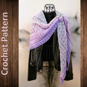 May include: A purple and gray crochet shawl with a decorative ring clasp. The shawl is draped over a black leather jacket.
