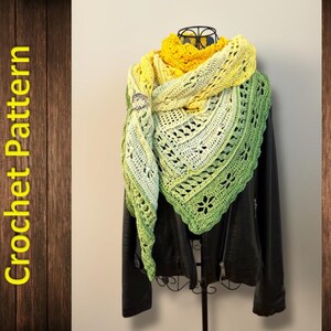 May include: A handmade crochet shawl in yellow and green hues, displayed on a black jacket. The shawl has an openwork design with floral patterns. The words "Crochet Pattern" are displayed vertically on a wooden background. The shawl is displayed on a stand.