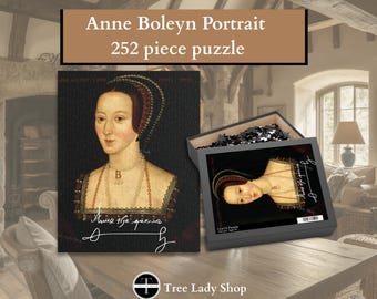 Pode incluir: Um quebra-cabeça de 252 peças com um retrato de Ana Bolena. A tampa da caixa exibe o mesmo retrato com o texto 'Anne the queen' e uma assinatura. As peças do quebra-cabeça estão visíveis dentro da caixa aberta, rotulada com 28x36 cm.