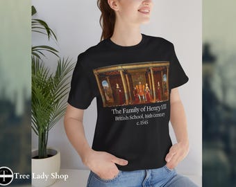 Pode incluir: T-shirt preto com uma pintura histórica de A Família de Henrique VIII. A pintura mostra figuras com roupas de época numa sala. O texto na camisa diz "The Family of Henry VIII, British School, 16th century, c. 1545."