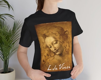 Pode incluir: T-shirt preto com um retrato em tons sépia de uma mulher e o texto "L da Vinci". A obra de arte é uma pintura clássica. A camisa é de gola redonda.