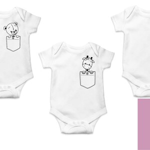 May include: Three white baby onesies with a pocket on the front. Each onesie features a different animal peeking out of the pocket: a bear, a giraffe, and an elephant. The animals are black and white.