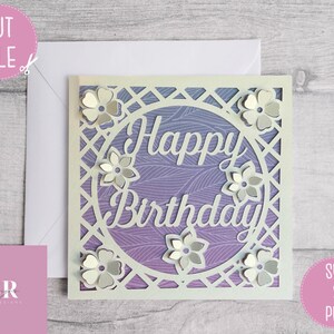 Op de afbeelding: Een witte kaart met een paarse en witte gepatroneerde achtergrond. De kaart heeft een uitgesneden ontwerp van een cirkel met de woorden "Happy Birthday" erin. De cirkel wordt omringd door een vierkant frame met een tralieontwerp. Er zijn kleine bloemen rond de cirkel.