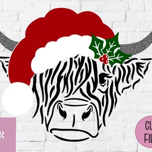K&ouml;nnte beinhalten: Schwarze und wei&szlig;e Silhouette eines Highland-Rinderkopfes, der einen roten Weihnachtsmann-Hut mit wei&szlig;em Bommel und gr&uuml;nem Ilex mit roten Beeren tr&auml;gt.