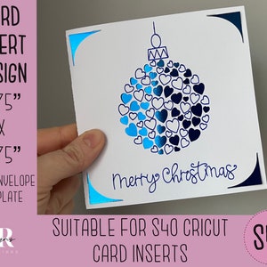 Può includere: Un biglietto bianco con un design di ornamento blu e bianco. L'ornamento è pieno di cuori blu e bianchi. Il testo "Merry Christmas" è scritto sotto l'ornamento. Il biglietto misura 4,75 pollici per 4,75 pollici.