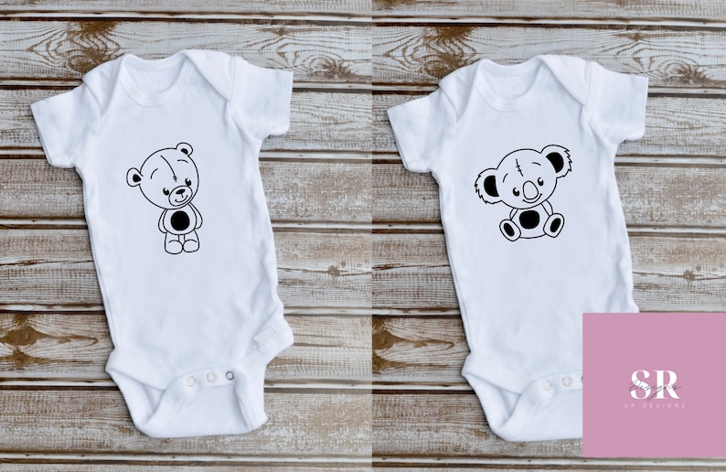 May include: Two white baby onesies with black and white cartoon animal designs. The onesie on the left features a bear and the onesie on the right features a koala.