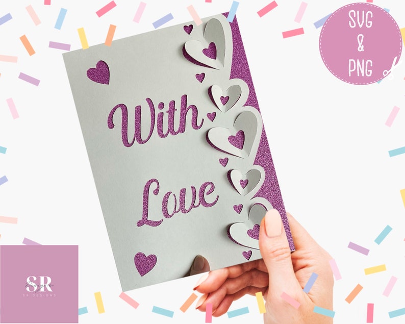 Pu&ograve; includere: Un biglietto bianco con le parole "With Love" in glitter viola. Il biglietto ha un bordo decorativo di cuori di carta sovrapposti.