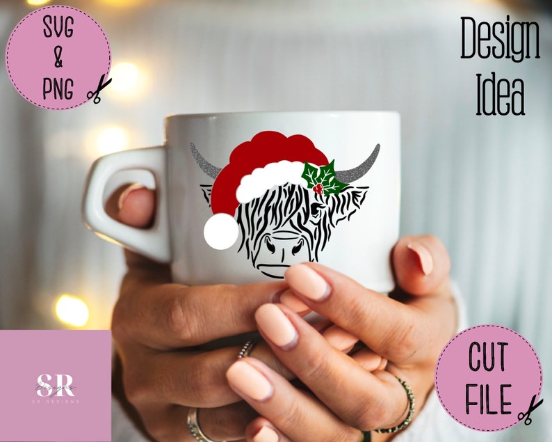 K&ouml;nnte beinhalten: Eine wei&szlig;e Keramiktasse mit einer schwarz-wei&szlig;en Highland-Kuh, die einen roten Weihnachtsmann-Hut und einen gr&uuml;nen Stechpalmenzweig tr&auml;gt. Die Tasse wird von den H&auml;nden einer Person gehalten.