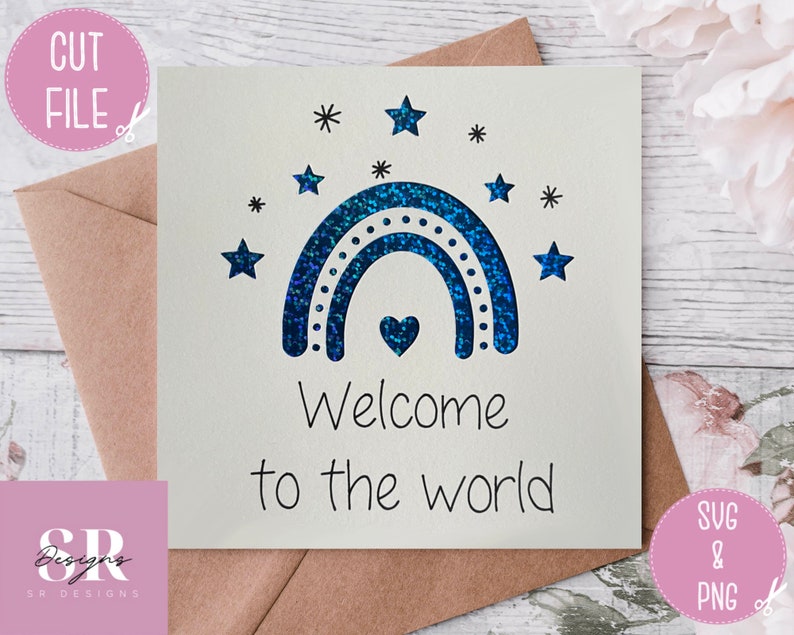 May include: A white card with a blue glitter rainbow and stars. The text "Welcome to the world" is written below the rainbow.