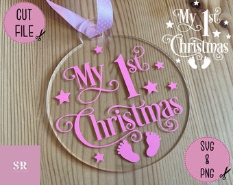 May include: Pink acrylic ornament with the text "My 1st Christmas" and two pink footprints. The ornament is decorated with small pink stars.