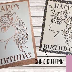 May include: A white card with a unicorn design cut out. The unicorn has a flower crown and the words "Happy Birthday" are written on the card.