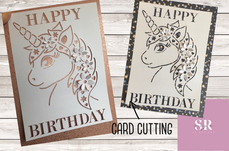 May include: A white card with a unicorn design cut out. The unicorn has a flower crown and the words "Happy Birthday" are written on the card.