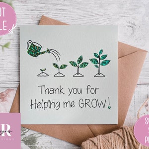 May include: A white card featuring a drawing of a watering can and growing plants, with the text "Thank you for Helping me GROW!". The watering can and plant leaves have a glittery green design. The card is on a brown envelope.