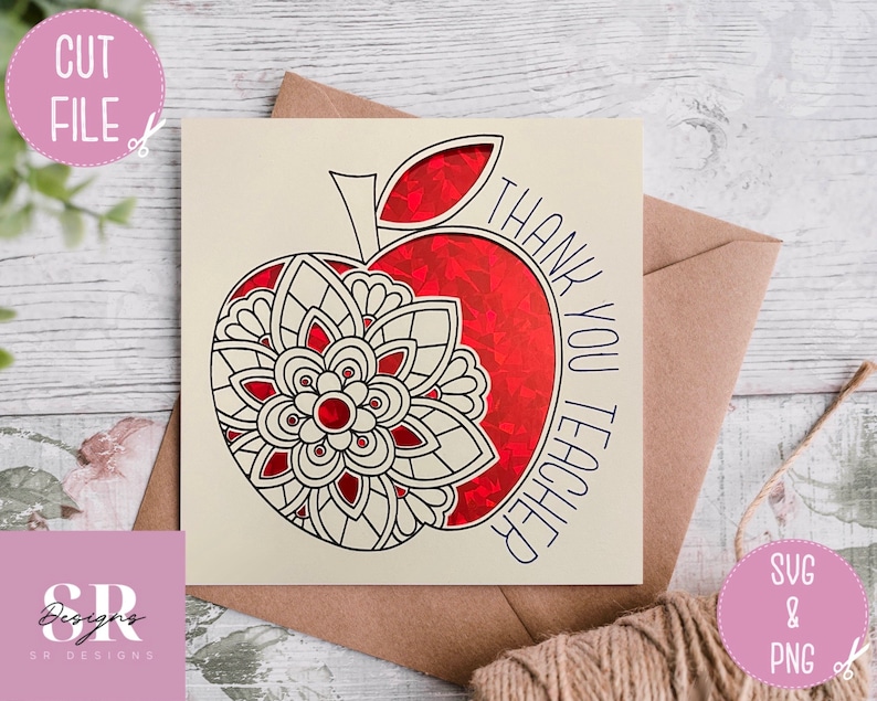 May include: A cream-coloured card with a red apple design and the words "THANK YOU TEACHER" in blue. The apple features a floral mandala design. The card is paired with a brown envelope and a twine string.