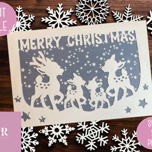 May include: A white card with a gray background featuring the text "Merry Christmas" and a silhouette of four deer with white stars on the gray background.