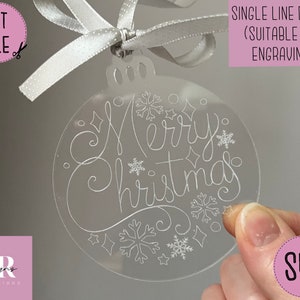 Könnte beinhalten: Ein transparenter Weihnachtsbaumschmuck aus Acryl mit den Worten "Merry Christmas", die in einer einzigen Zeile graviert sind. Der Schmuck ist mit Schneeflocken und Sternen verziert.