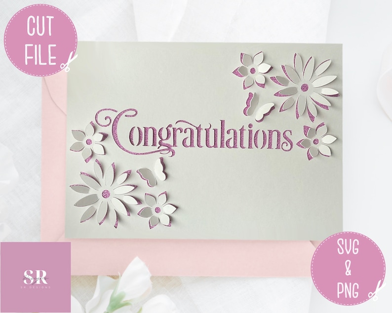 May include: A white card with a purple glitter design that says "Congratulations" with a floral design around the text. The card is on a pink background.
