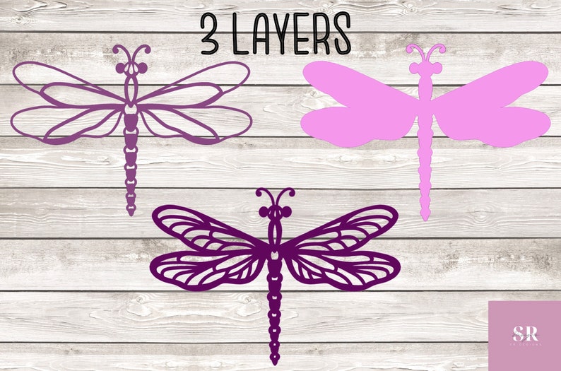 May include: Three layered purple and pink dragonfly cutouts on a white wood background. The text "3 LAYERS" is at the top of the image.
