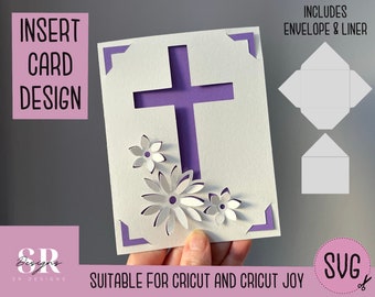 May include: A purple cross with white flowers cut out of a white card. The card is designed to be an insert card for a greeting card. The text "INCLUDES ENVELOPE & LINER" is visible in the upper right corner of the image. The text "SUITABLE FOR CRICUT AND CRICUT JOY" is visible in the lower right corner of the image. The text "SVG" is visible in the lower right corner of the image.