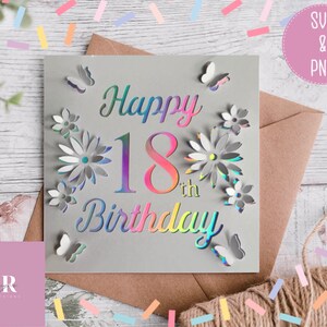 May include: A gray card with a holographic finish featuring the text "Happy 18th Birthday" with a floral design and butterflies. The card is on a brown envelope with confetti scattered around it.