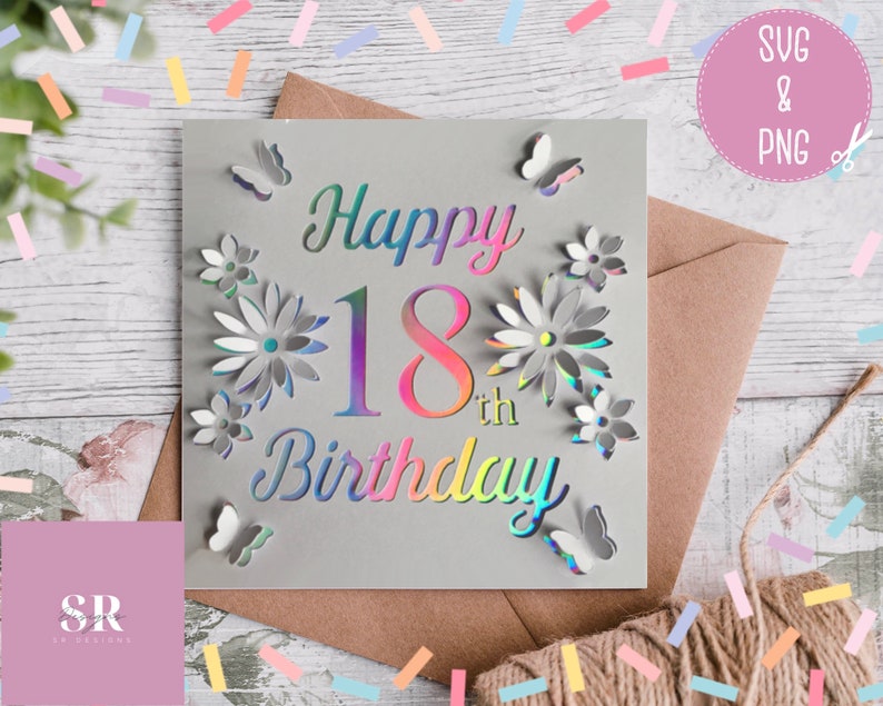 May include: A gray card with a holographic finish featuring the text "Happy 18th Birthday" with a floral design and butterflies. The card is on a brown envelope with confetti scattered around it.