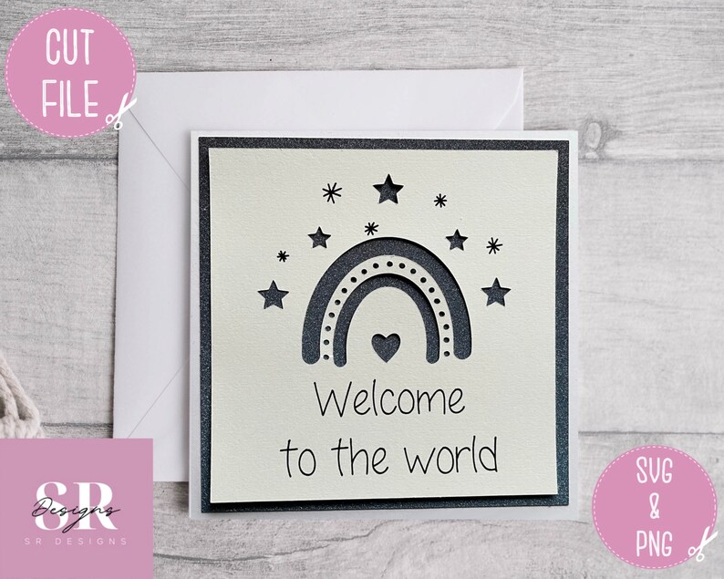 May include: A white card with a black and white rainbow, stars, and a heart. The text "Welcome to the world" is written below the rainbow.