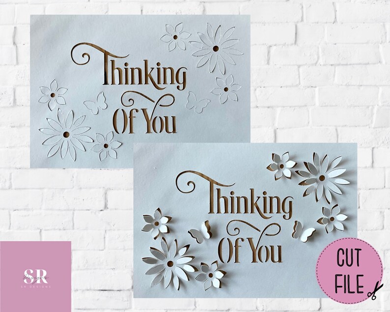 May include: Two white cards with the text "Thinking of You" in brown script. The cards have intricate cut-out designs of flowers and butterflies.