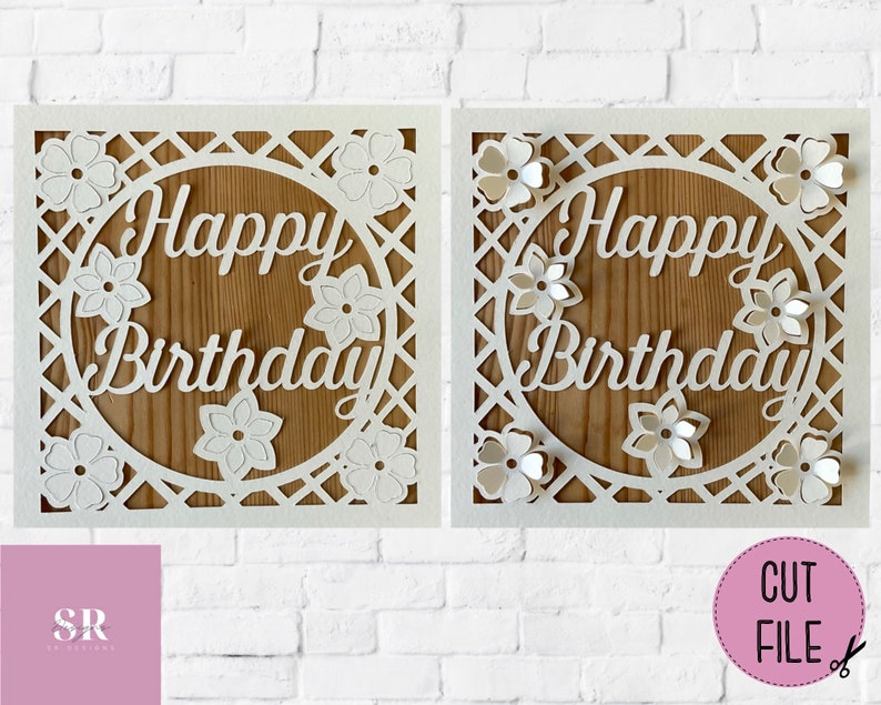 Op de afbeelding: Witte kaart met een uitgesneden ontwerp met een cirkel met de woorden "Happy Birthday" erin. De cirkel is omgeven door een traliewerkontwerp en bloemen.