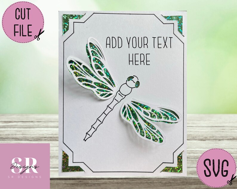May include: A white card with a black frame and a green dragonfly cut out. The card has the text "ADD YOUR TEXT HERE" in black.