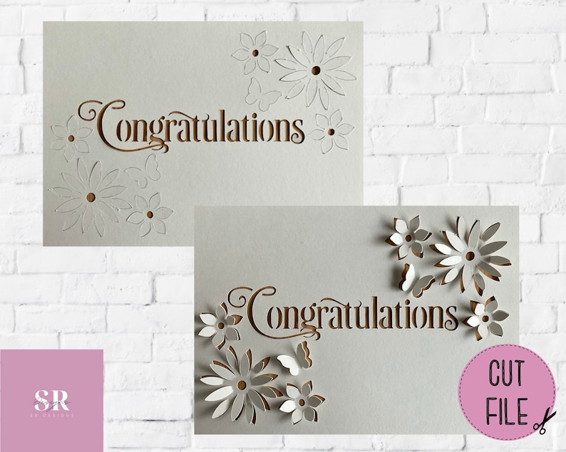 May include: Two white cards with the word "Congratulations" cut out in a brown font. The cards are decorated with white paper flowers and butterflies. The text "CUT FILE" is in a pink circle on the bottom right corner of the image.