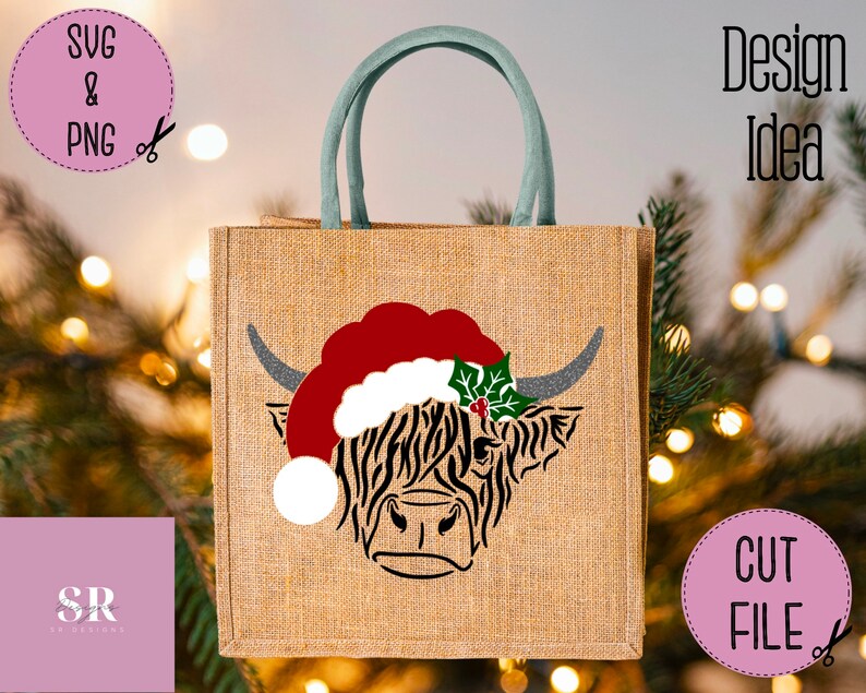 K&ouml;nnte beinhalten: Eine Jute-Tragetasche mit einem Design einer schottischen Hochlandkuh, die einen Weihnachtsmann-Hut mit Stechpalme tr&auml;gt. Die Tasche hat einen gr&uuml;nen Griff.